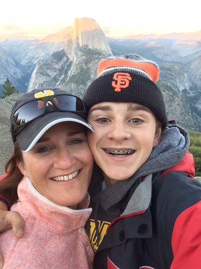 A picture of Ms. Frey with her teenage son at Yosemite Glacier Point.
